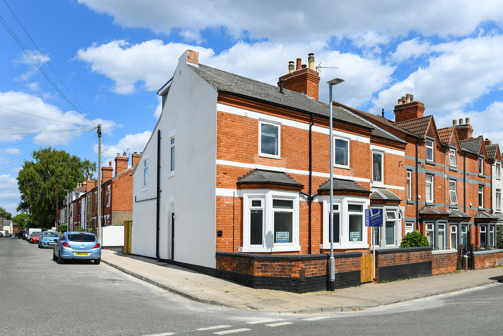 Corner view of the completed property with red brick frontage and white rendered side wall